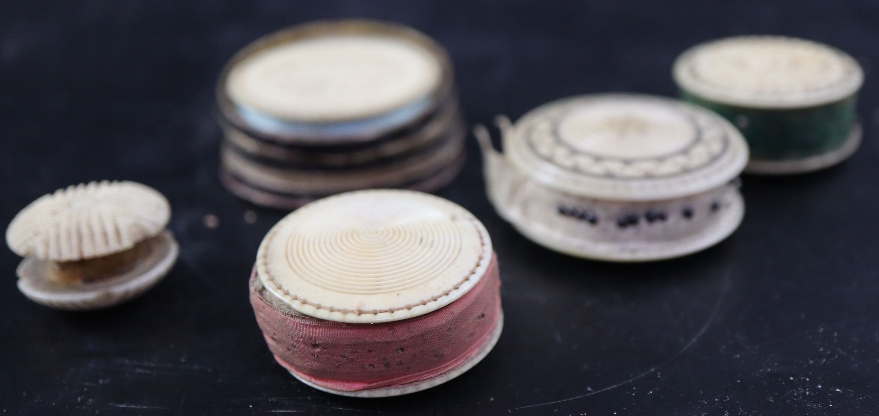 A collection of twelve 19th century carved ivory and bone pin cushions